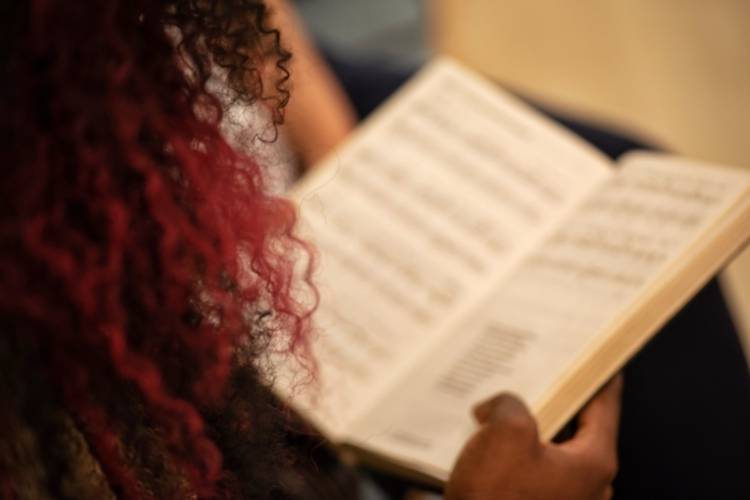 Mulher estudando músicas na Bíblia que podem ser usadas no Natal para o Ministério Infantil.