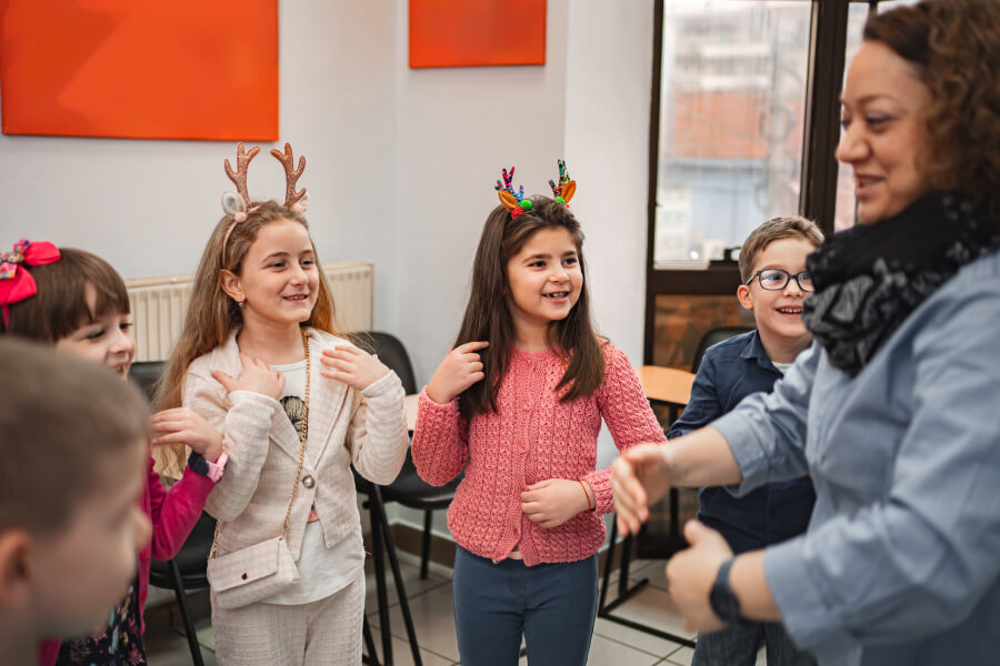 Crianças participando de uma apresentação de Natal infantil na igreja, cantando e interagindo com alegria durante o ensaio.