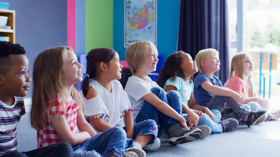 Crianças sentadas em sala colorida participando de atividade educativa, representando ideias e inspirações para Nomes para Ministério Infantil.