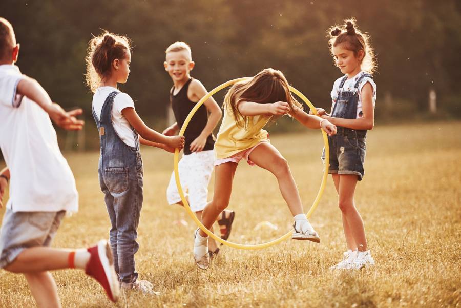 Grupo de crianças brincando ao ar livre em dinâmica da EBF infantil com atividades educativas e recreativas.