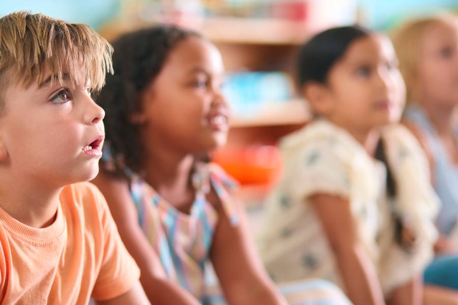 Crianças participando de aula bíblica infantil em momento de aprendizado e atenção durante atividade educativa.