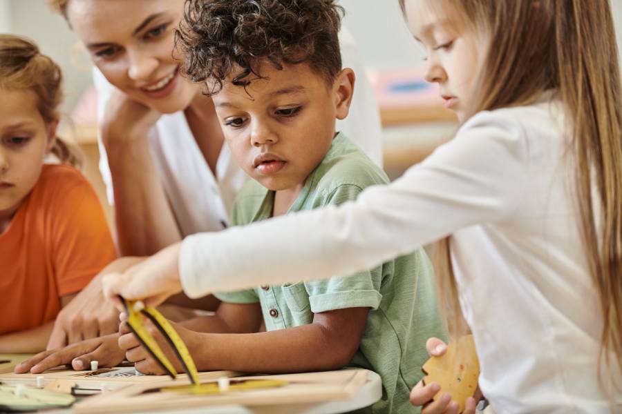 Professora e crianças em atividade educativa em sala de aula, representando aula sobre parábola do semeador para crianças 